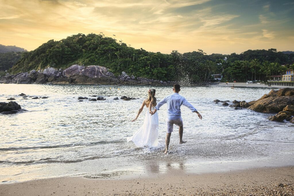 pexels photo 10624602 10624602 A couple joyfully walks along the shore at sunset, embracing romance by the sea.